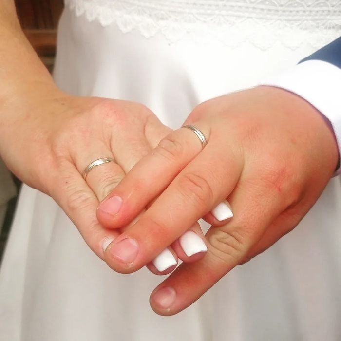 Alianzas de boda: nos adaptamos a tu forma de ser, vida diaria y presupuesto Mano de novia y mano de novio entrelazadas, ambas llevan anillos de boda.
